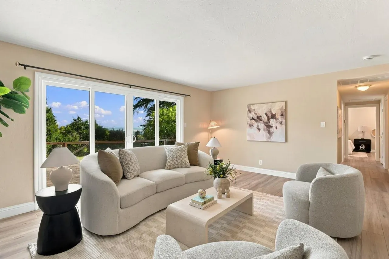 Staged living room with a curved cream sofa, bouclé chairs and sliding doors